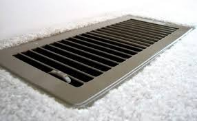 Close-up of a floor vent for ducted heating system providing warm airflow in a home interior.
